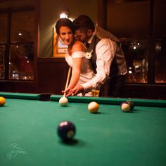 the bride and groom are playing pool together