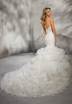 a woman in a white wedding dress standing next to a wall with graffiti on it