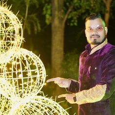 a man standing next to a lighted sculpture