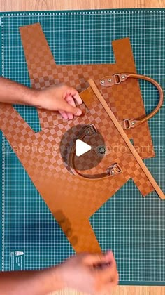 someone is making a handbag out of brown leather