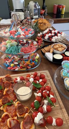 a wooden table topped with lots of different types of foods and desserts on top of it