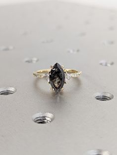 a black and white diamond ring sitting on top of a table