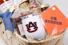 a basket filled with food and drinks on top of a white table next to a blue ribbon