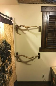 the bathroom is decorated with antlers on the shower curtain and wood window shutters