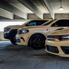 two white dodge vehicles parked in a parking garage