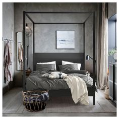 a bedroom with a four poster bed and grey walls