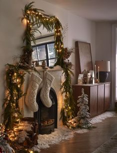 a decorated fireplace with stockings and christmas lights