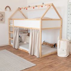 a child's bed with a wooden structure and curtains on the bottom bunk, next to a white rug