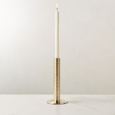 a tall white candle sitting on top of a table