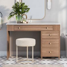 a vanity with a stool, mirror and potted plant