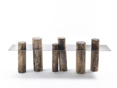 a glass table topped with wooden logs