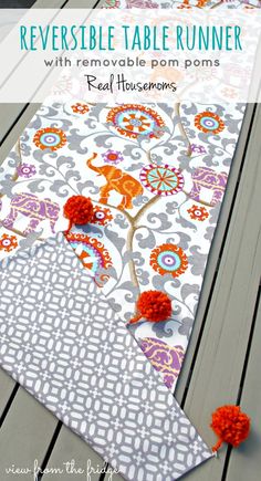 a table runner with orange pom poms on it and the words reversible table