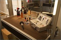 an open suitcase sitting on top of a counter next to makeup brushes and other items