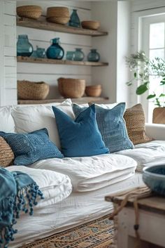 a living room filled with lots of furniture and pillows on top of a white couch