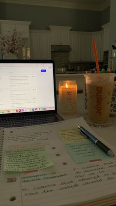 an open laptop computer sitting on top of a desk next to a cup of coffee