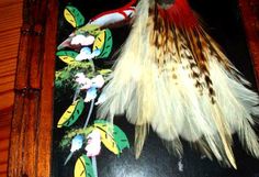 feathers are laid out on a table in front of a wooden frame with an ornament