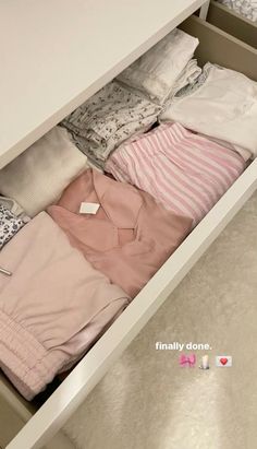 an open drawer with clothes in it