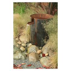 a water fountain surrounded by rocks and plants