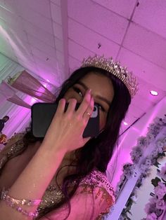 a woman wearing a tiara talking on a cell phone