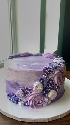 a cake with purple frosting and flowers on it