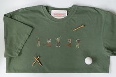 Olive green Comfort Colors shirt with neutral-colored minimal golfers embroidered on the front (10x2in) and a golf hole (1.5in) embroidered on the back below the collar. Green Cotton Golf T-shirt, Green Cotton T-shirt For Golf, Cotton Golf Tops, Green Cotton Golf Tops, Green Crew Neck Top For Golf, Green Cotton Tops For Golf, Embroidery Tshirt, Golf 1, Comfort Colors Shirt