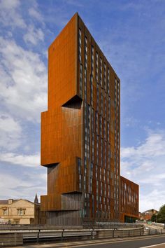 an orange building is on the side of a road in front of a blue sky