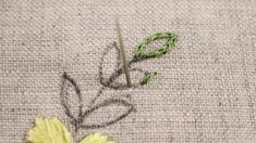 a close up of a flower on a piece of cloth with scissors and thread next to it