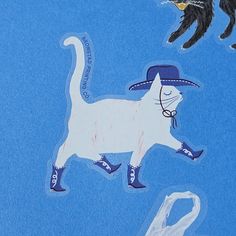 a white cat wearing a blue hat and boots with two black birds in the background