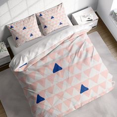 a bed with pink and blue triangles on it