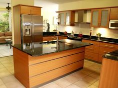 a large kitchen with an island in the middle and stainless steel appliances on both sides