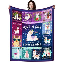 a woman holding up a purple blanket with llamas and unicorns on it