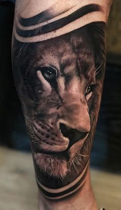 a man's leg with a lion tattoo on it and the head of a tiger