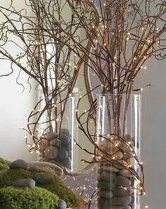 a vase filled with moss and rocks on top of a table next to a mirror