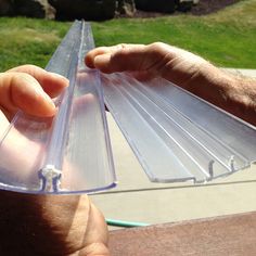 a person is holding some clear plastic items in their hands and they are on the table outside