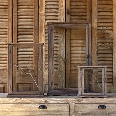 an old wooden cabinet with three doors and two drawers in front of the door is made out of wood shutters