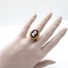 This is part of Chairish’s Fine Jewelry assortment.  This beautiful Victorian 14k gold cameo ring, circa the turn of the century, features the profile of a helmeted warrior carved out of red sardonyx. The top layer of the stone, where the warrior is carved in incredible detail, is a creamy white, while the remaining oval is a glowing peachy colour. The warrior wears a roman style helmet, topped with a delicate feather, and has an expressive face and flowing dressing gown. The cameo is bezel set, Roman Style, Roman Fashion, Cameo Ring, Turn Of The Century, The Warrior, Dressing Gown, Creamy White, Ring Size 7, Signet Ring