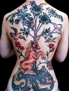 the back of a woman's body with an unicorn and birds tattoo on it