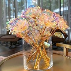 a glass vase filled with flowers on top of a table