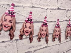 a group of women wearing birthday hats hanging on a brick wall