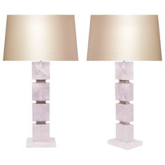 a pair of white marble lamps with beige shades