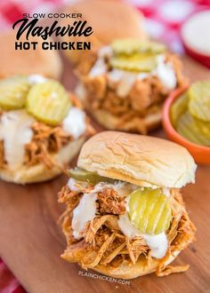 three pulled pork sliders with pickles and mayonnaise on a cutting board