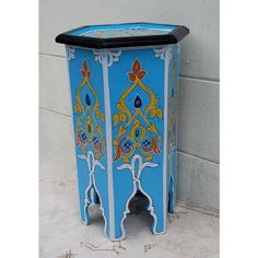 a blue and yellow painted cabinet next to a wall