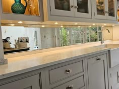 a large kitchen with white cabinets and marble counter tops