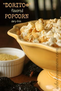 a yellow bowl filled with popcorn next to some raisins