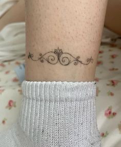 a woman's foot with a small tattoo on the side of her leg,