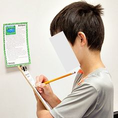 a young man holding a pencil in his right hand while writing on a piece of paper