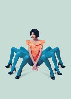 a woman in blue tights and heels sitting on the ground with her legs crossed