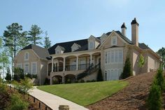 a large house on top of a hill with stairs leading up to the front door