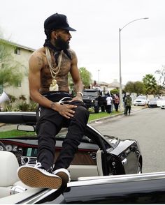 a man sitting on the hood of a car