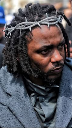 a man with dreadlocks wearing a crown of barbed wire on top of his head